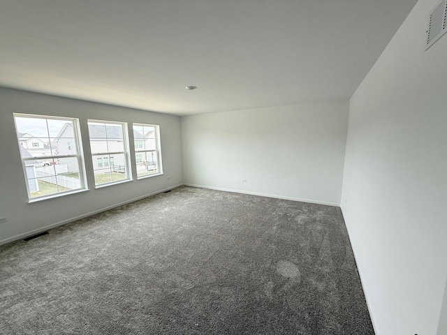 carpeted empty room featuring visible vents and baseboards
