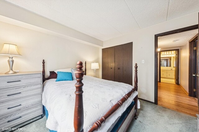 bedroom featuring a closet, a textured ceiling, and light colored carpet