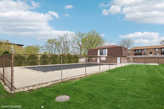 view of swimming pool with a yard and fence