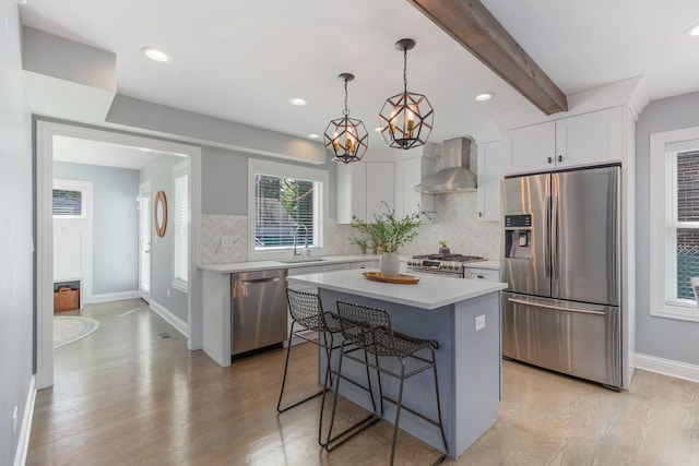 1137 Griffith Rd, Lake Forest, IL 60045 - kitchen featuring stainless steel appliances, wall chimney range hood, a sink, light countertops, and light wood finished floors