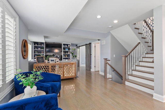 1137 Griffith Rd, Lake Forest, IL 60045 - living area featuring wood finished floors, a barn door, baseboards, recessed lighting, and stairs