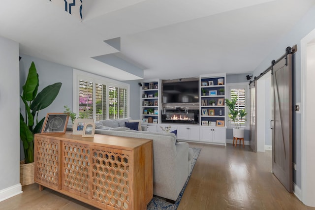 1137 Griffith Rd, Lake Forest, IL 60045 - living room featuring a barn door, wood finished floors, a glass covered fireplace, and baseboards
