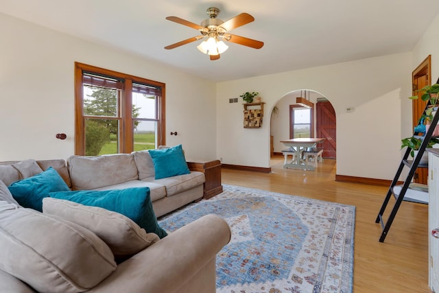 13459 N Tower Rd N, Lee, IL 60530 - living room featuring arched walkways, a ceiling fan, light wood-type flooring, and baseboards