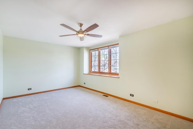 spare room with baseboards, visible vents, ceiling fan, and carpet