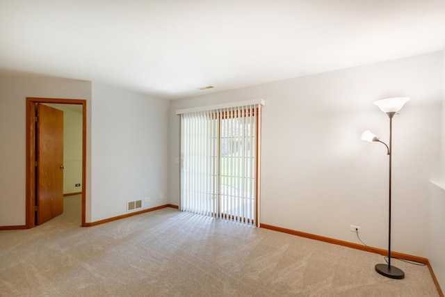 spare room with visible vents, carpet, and baseboards