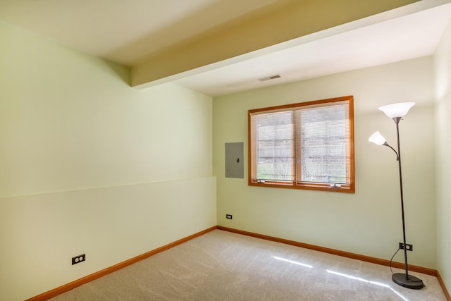 empty room featuring visible vents, baseboards, carpet floors, and electric panel