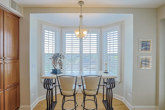 dining room featuring baseboards, visible vents, and light wood-type flooring