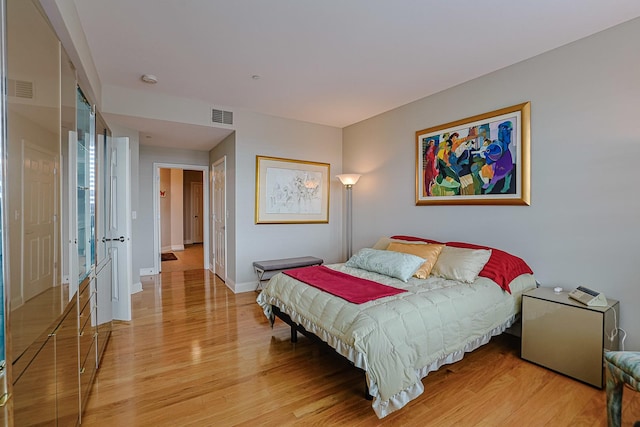 bedroom featuring visible vents, baseboards, and light wood-type flooring
