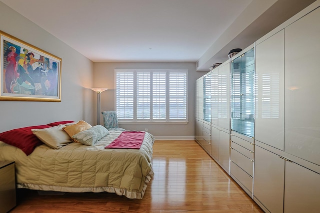 bedroom with light wood-type flooring and baseboards