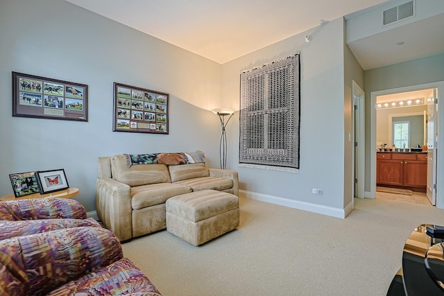 living room featuring visible vents, baseboards, and light carpet