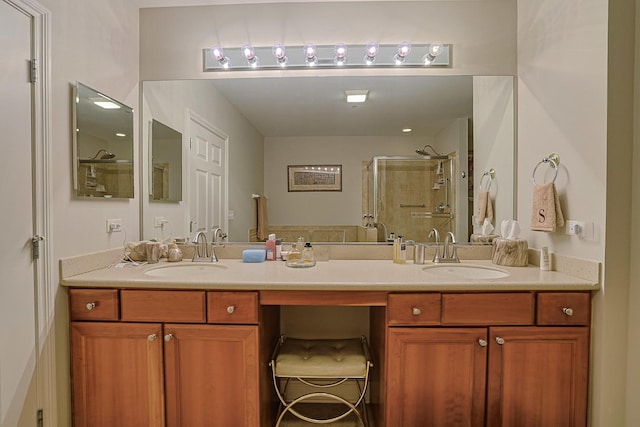 bathroom featuring a stall shower, double vanity, and a sink
