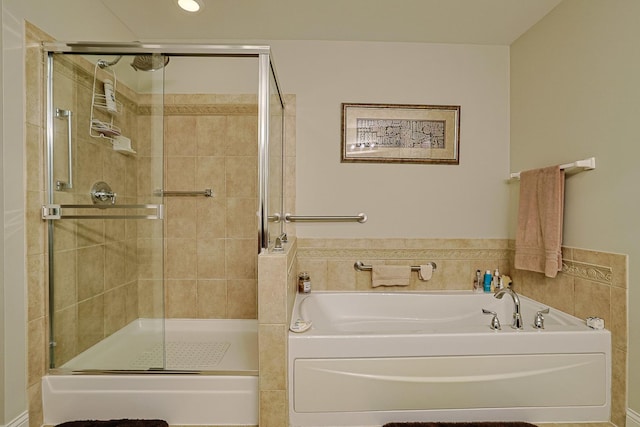 bathroom with recessed lighting, a stall shower, and a garden tub
