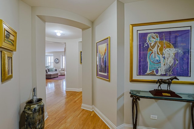 hall with baseboards and light wood-type flooring