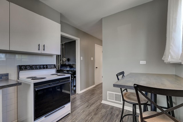479 Oak St, Des Plaines, IL 60016 - kitchen featuring tasteful backsplash, wood finished floors, electric range, baseboards, and visible vents