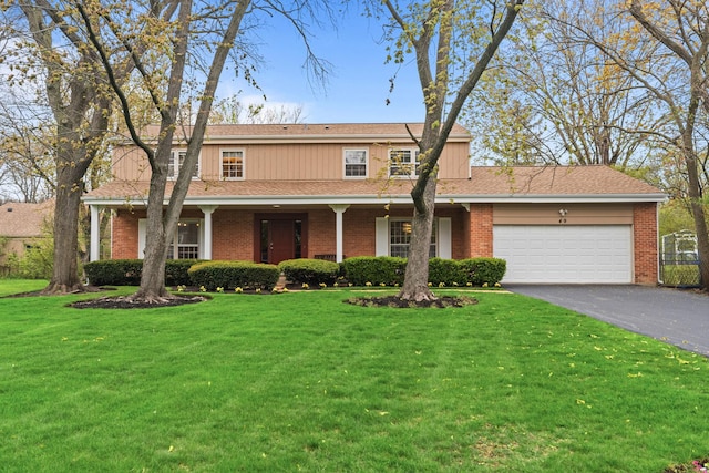 49 Red Oak Ln, Highland Park, IL 60035 - traditional home featuring driveway, an attached garage, a front yard, and brick siding