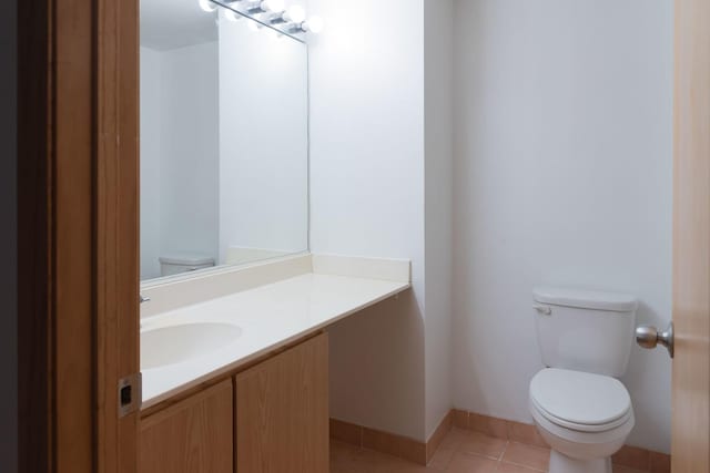 1250 W Van Buren St Unit 203, Chicago, IL 60607 - half bathroom featuring toilet, vanity, tile patterned floors, and baseboards