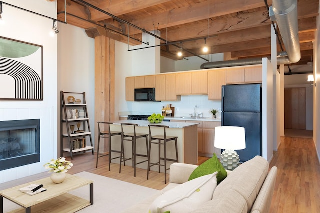 1250 W Van Buren St Unit 203, Chicago, IL 60607 - kitchen with black appliances, light brown cabinets, light countertops, light wood-style floors, and a center island