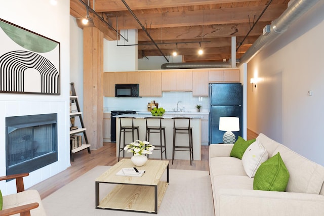 1250 W Van Buren St Unit 203, Chicago, IL 60607 - living room featuring light wood-type flooring, beamed ceiling, and a fireplace