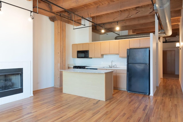 1250 W Van Buren St Unit 203, Chicago, IL 60607 - kitchen with black appliances, light brown cabinetry, light countertops, a sink, and a high ceiling