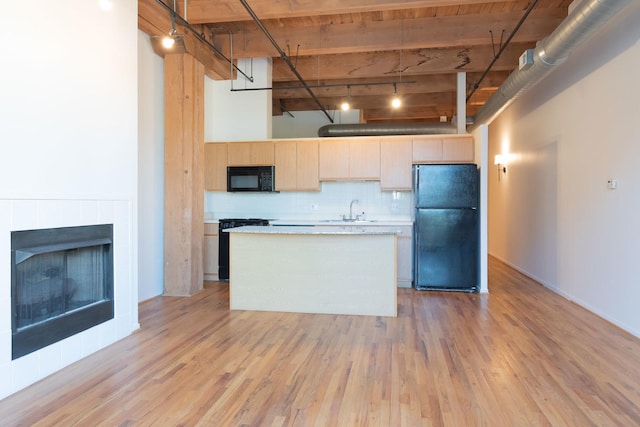 1250 W Van Buren St Unit 203, Chicago, IL 60607 - kitchen featuring black appliances, a sink, a center island, light brown cabinetry, and light wood finished floors