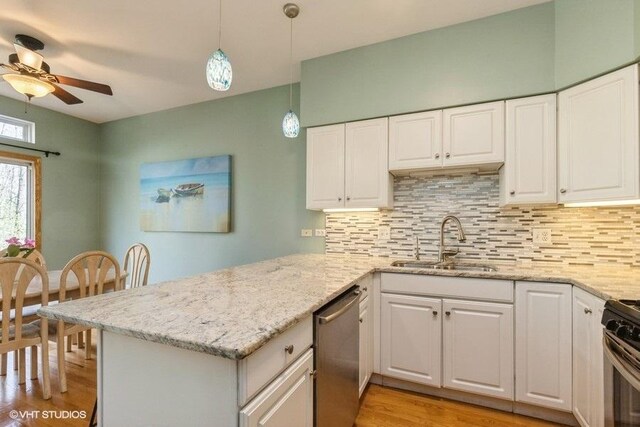 kitchen featuring a peninsula, ceiling fan, white cabinets, a sink, and appliances with stainless steel finishes