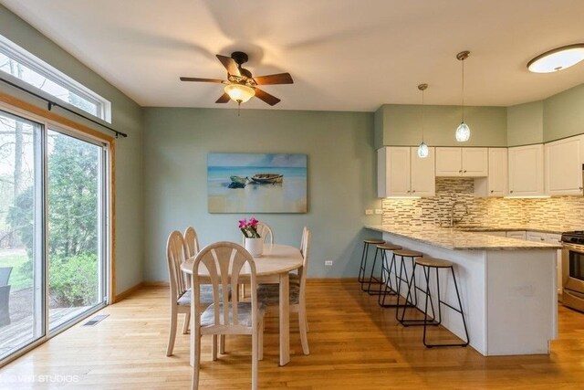 kitchen with plenty of natural light, decorative backsplash, a peninsula, and stainless steel gas range oven
