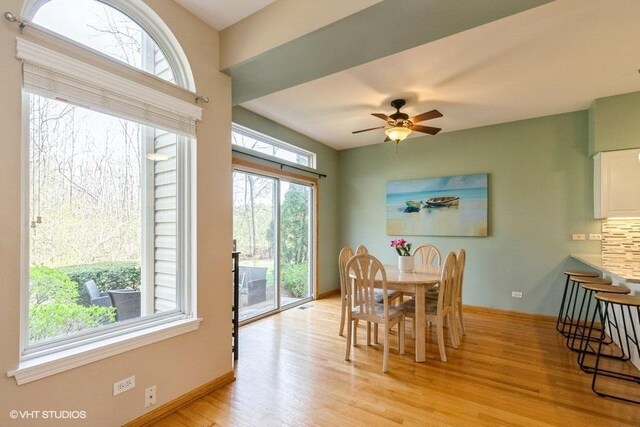 dining space featuring baseboards, a ceiling fan, and light wood finished floors