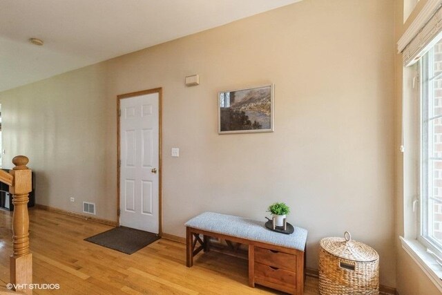foyer featuring visible vents, baseboards, plenty of natural light, and light wood-type flooring