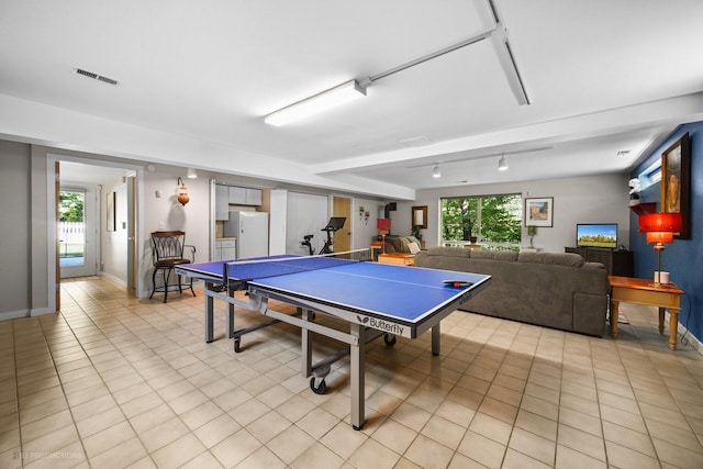 game room with visible vents, rail lighting, baseboards, and light tile patterned floors