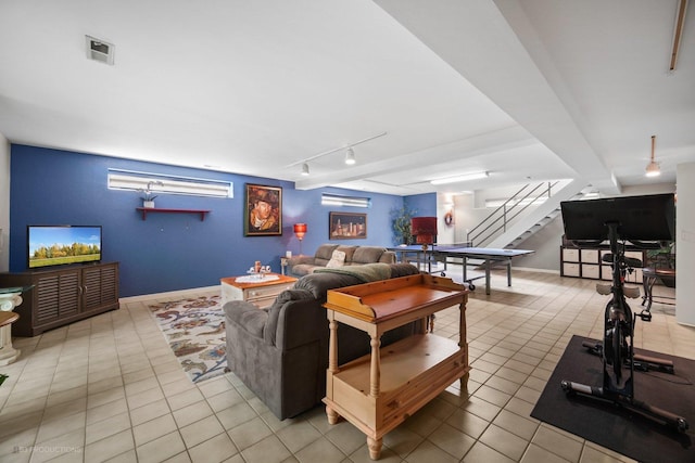 living area with visible vents, rail lighting, light tile patterned floors, and stairway