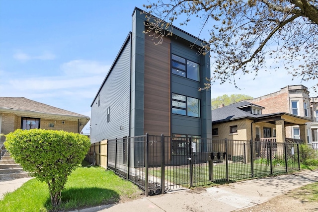 view of front facade with brick siding, a fenced front yard, and a front yard