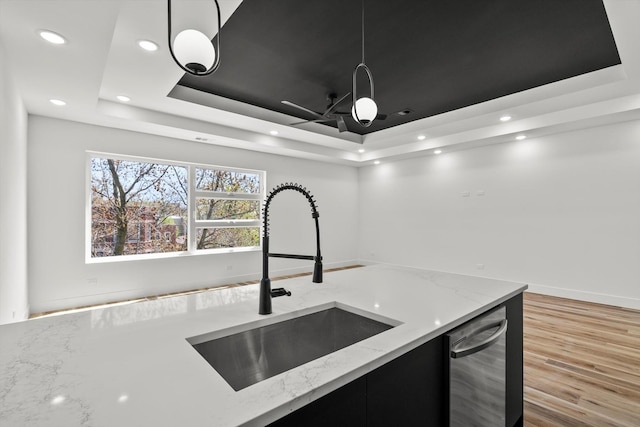 kitchen with a sink, dark cabinets, recessed lighting, and a raised ceiling