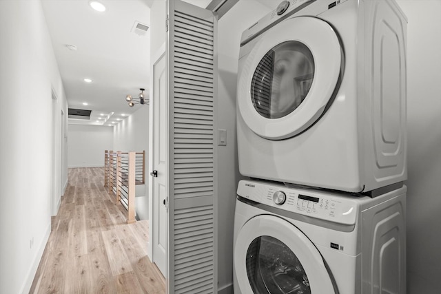 laundry room featuring laundry area, stacked washer / dryer, baseboards, recessed lighting, and light wood-type flooring