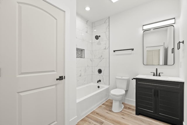 bathroom featuring shower / tub combination, vanity, toilet, baseboards, and wood finished floors