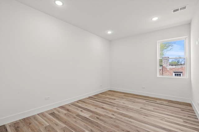 spare room with baseboards, recessed lighting, light wood-style flooring, and visible vents