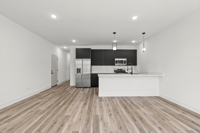 kitchen featuring dark cabinetry, stainless steel appliances, recessed lighting, and light countertops