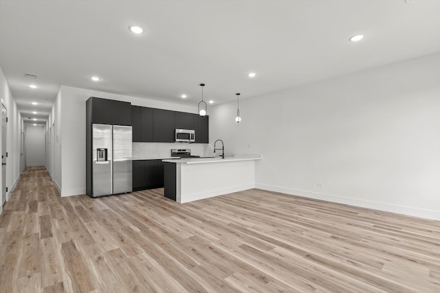 kitchen featuring light countertops, stainless steel appliances, recessed lighting, and dark cabinets