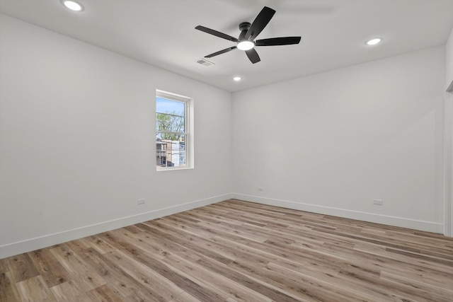empty room featuring recessed lighting, baseboards, and light wood-type flooring