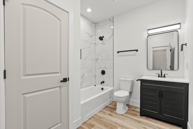 bathroom featuring shower / tub combination, vanity, toilet, baseboards, and wood finished floors