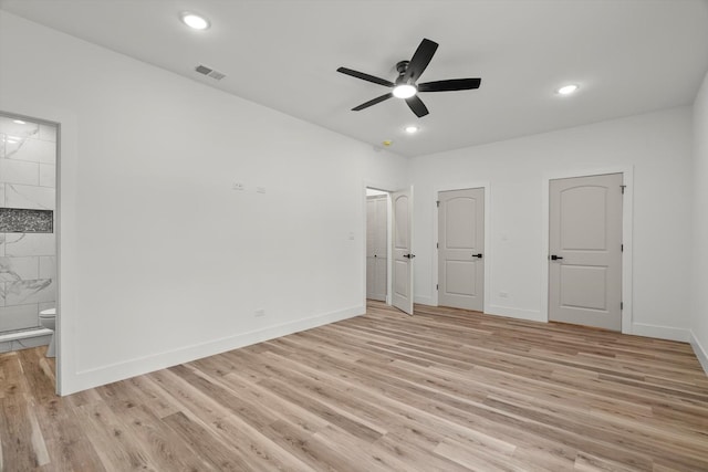 unfurnished bedroom featuring light wood-style floors, baseboards, connected bathroom, and visible vents