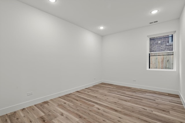 empty room featuring visible vents, light wood-style flooring, baseboards, and recessed lighting