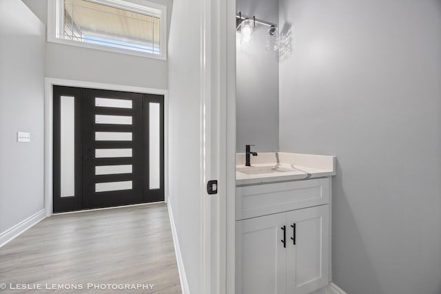 bathroom featuring wood finished floors, vanity, and baseboards