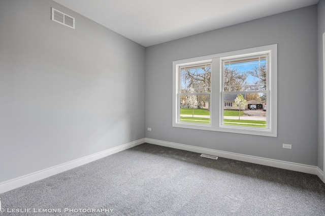 empty room with visible vents, carpet, and baseboards