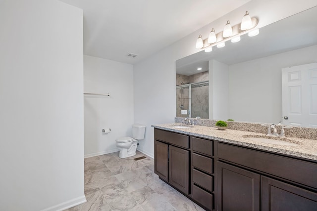 full bathroom featuring a shower stall, toilet, double vanity, and baseboards
