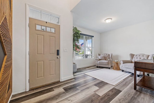 foyer entrance with wood finished floors and baseboards