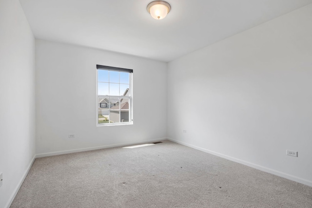spare room featuring carpet floors and baseboards