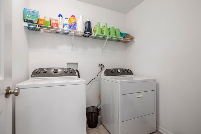 clothes washing area with independent washer and dryer and light marble finish floors