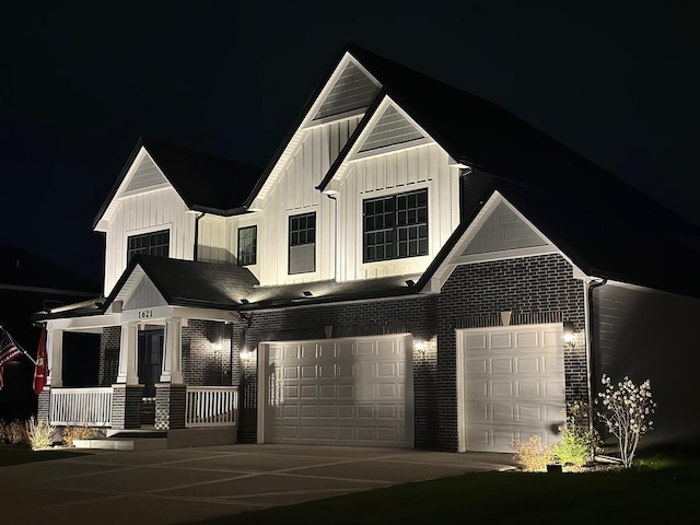 view of front facade with an attached garage, board and batten siding, covered porch, driveway, and brick siding