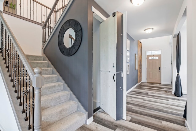 stairway with wood finished floors and baseboards