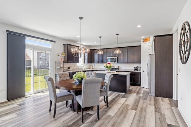 dining area featuring light wood finished floors, recessed lighting, and a chandelier